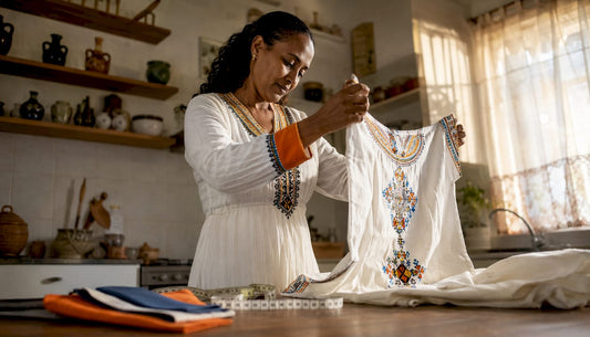 Woman inspecting traditional African dress at table